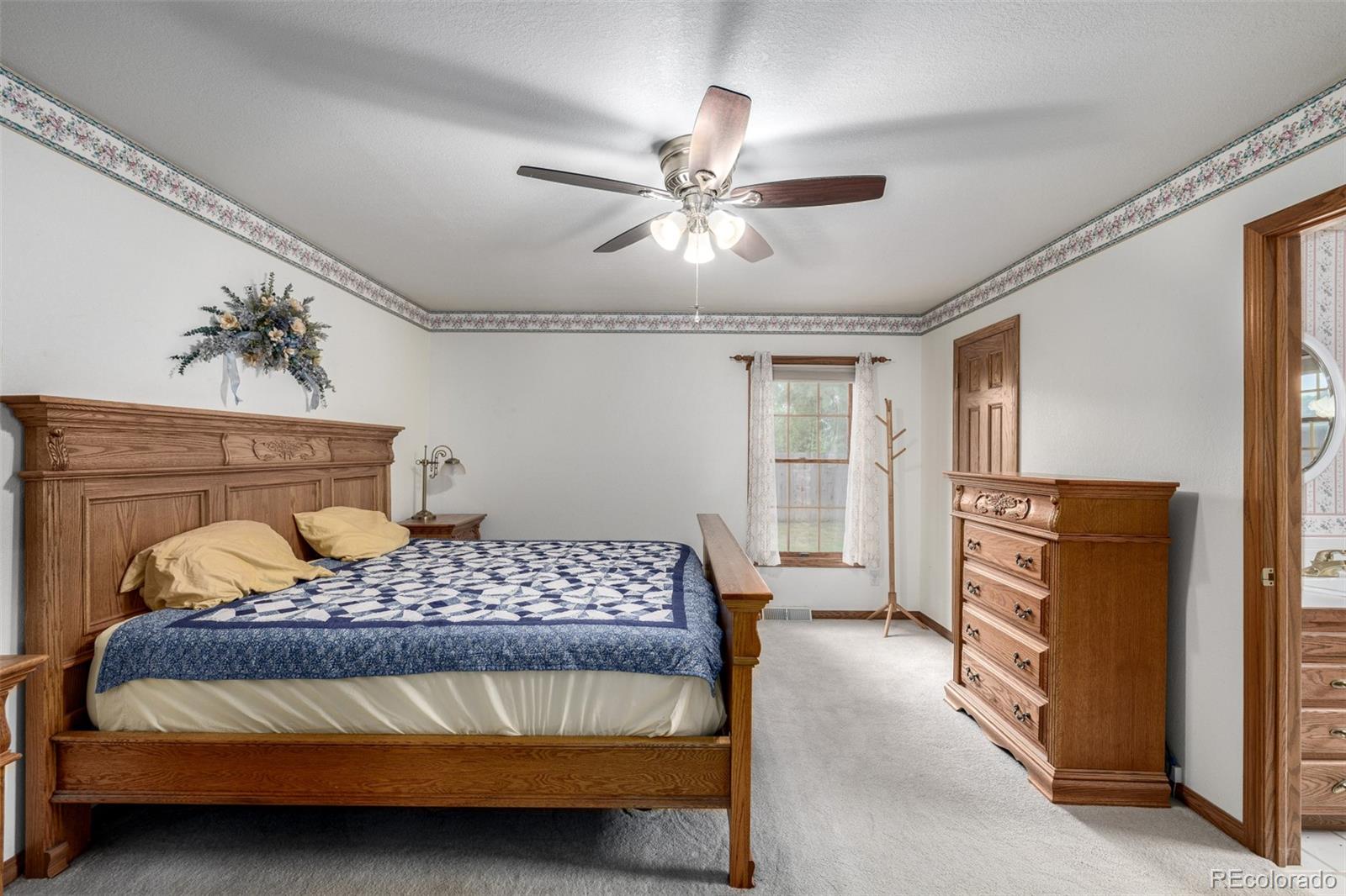 909 Fairhurst Street Sterling, CO 80751 - Photo 27 of 50 a bedroom with a bed and a chandelier