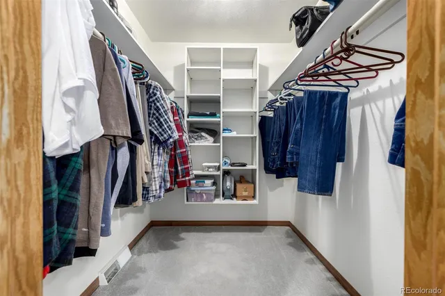 a view of walk in closet with clothes and shoes