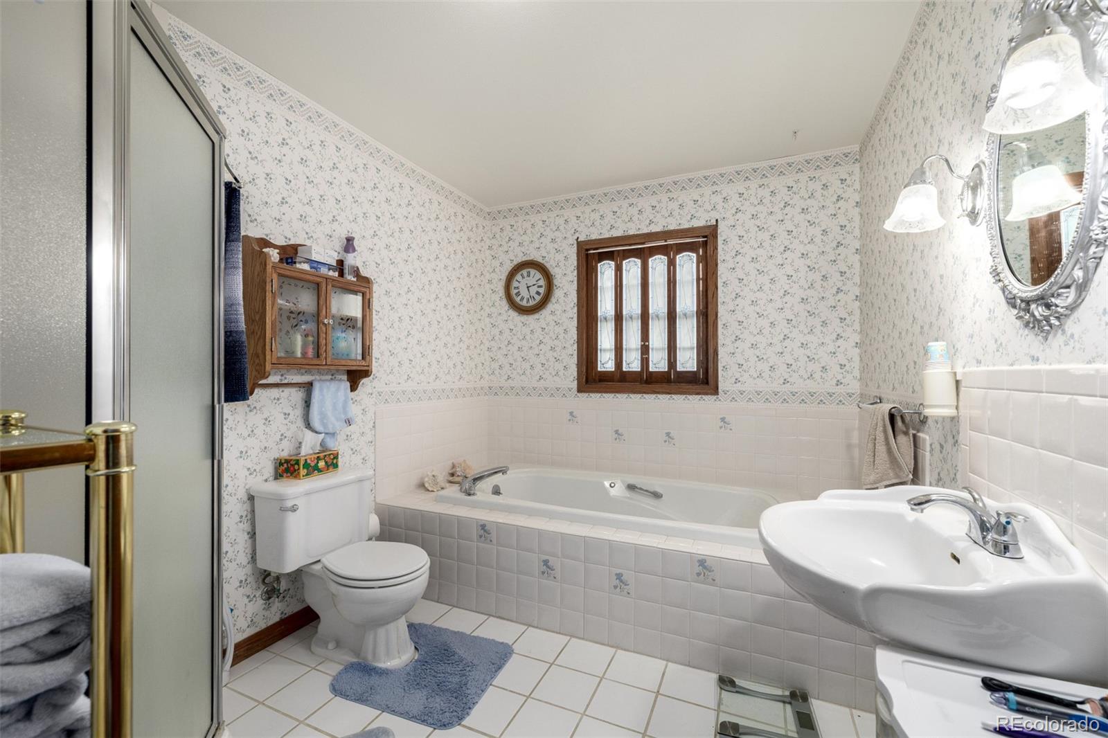 909 Fairhurst Street Sterling, CO 80751 - Photo 36 of 50 a bathroom with a sink toilet a mirror and bathtub