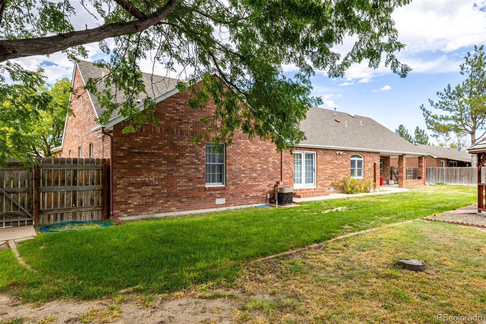 909 Fairhurst Street Sterling, CO 80751 - Photo 48 of 50 a front view of a house with a garden and trees