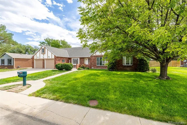 a front view of a house with a yard and tree