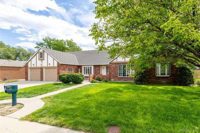 a front view of a house with a yard and trees