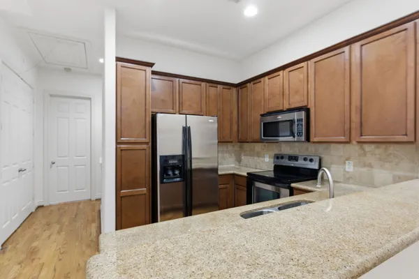 a kitchen with granite countertop a refrigerator and a sink