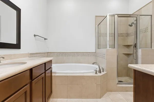 a bathroom with a tub sink and mirror