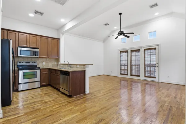 a kitchen with a refrigerator a microwave a sink and cabinets