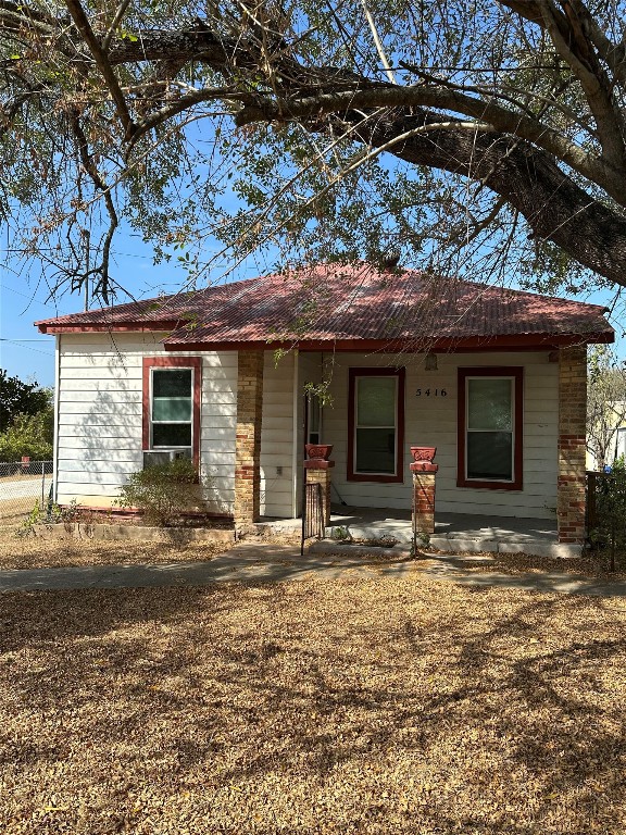 a front view of a house with yard outdoor seating and covered with trees