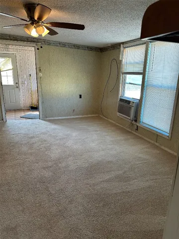 en empty room with windows and fan