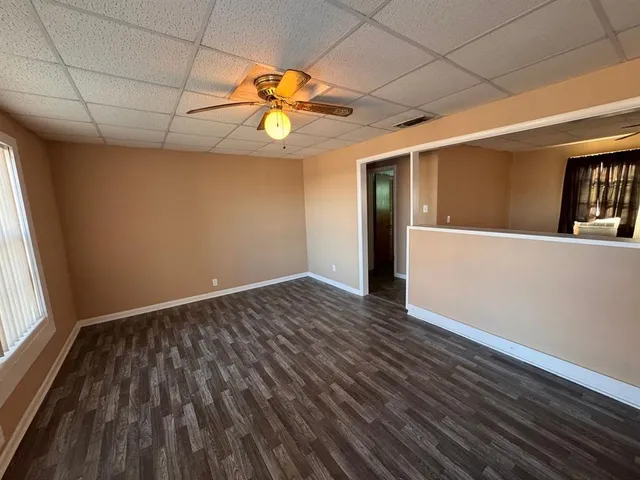 en empty room with wooden floor and windows