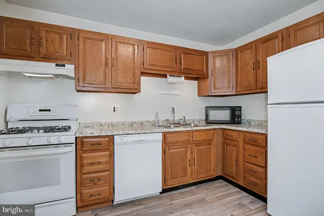 a kitchen with a sink a refrigerator a microwave and cabinets