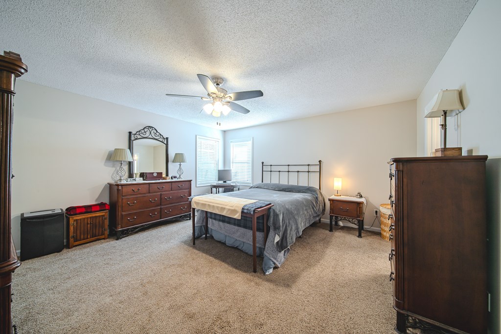 200 Lake Amah Lee Road Hampton, GA 30228 - Photo 26 of 29 a spacious bedroom with a bed dresser and a mirror