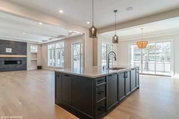 a large kitchen with stainless steel appliances granite countertop a lot of counter space and wooden floors