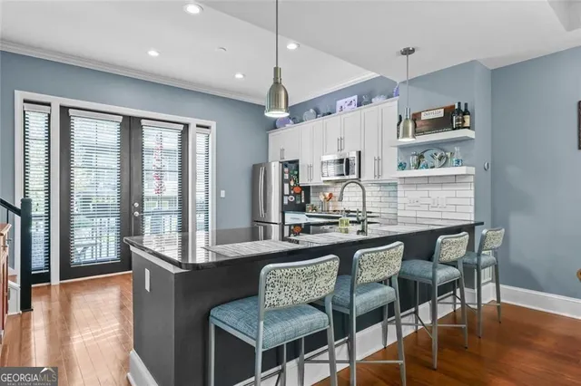 a kitchen with stainless steel appliances granite countertop a stove a sink and a microwave