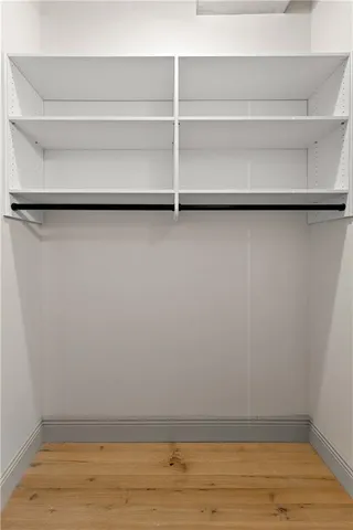 a view of walk in closet with empty racks
