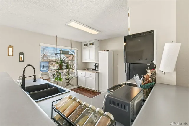 a kitchen with stainless steel appliances granite countertop a refrigerator a sink a stove and white cabinets