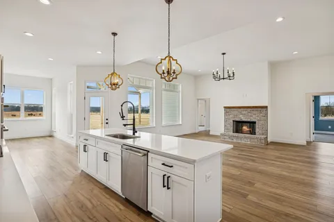 a view of a livingroom with a fireplace a chandelier and wooden floor