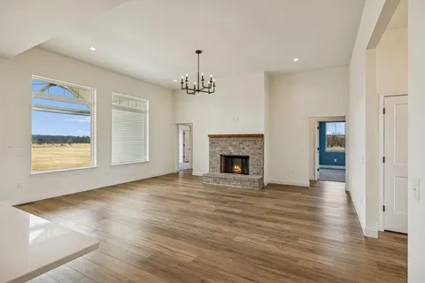 a kitchen with stainless steel appliances a sink a kitchen island a stove and a refrigerator with wooden floor