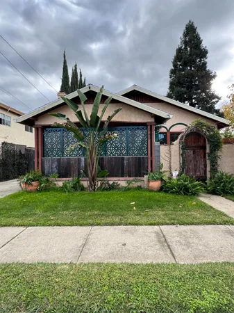 a front view of a house with a garden and plants