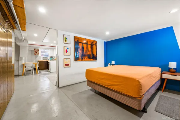 a bed sitting in a room next to a lamp