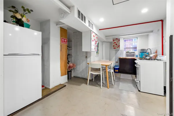 a dining room with furniture and a refrigerator