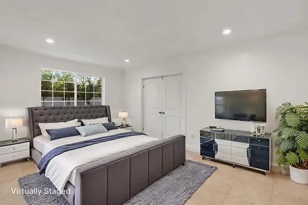 a bedroom with a bed and a flat screen tv