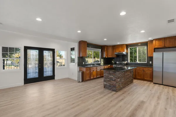 a large living room with stainless steel appliances granite countertop a couch and a large window