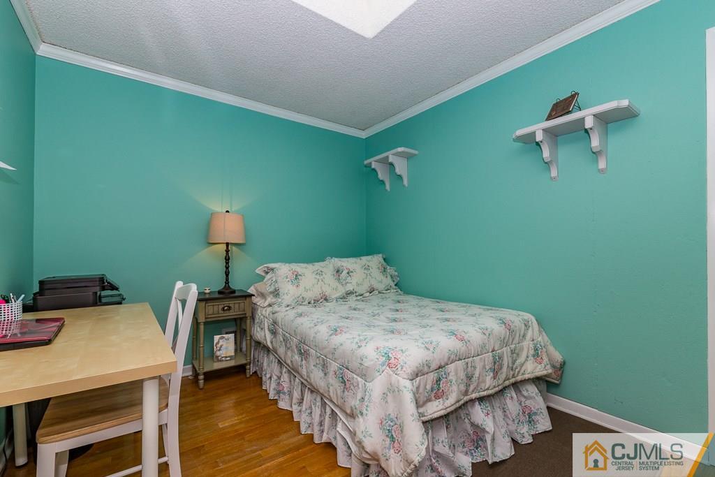 53 Rector Avenue Woodbridge, NJ 07095 - Photo 18 of 25 a bedroom with a bed and a table in it