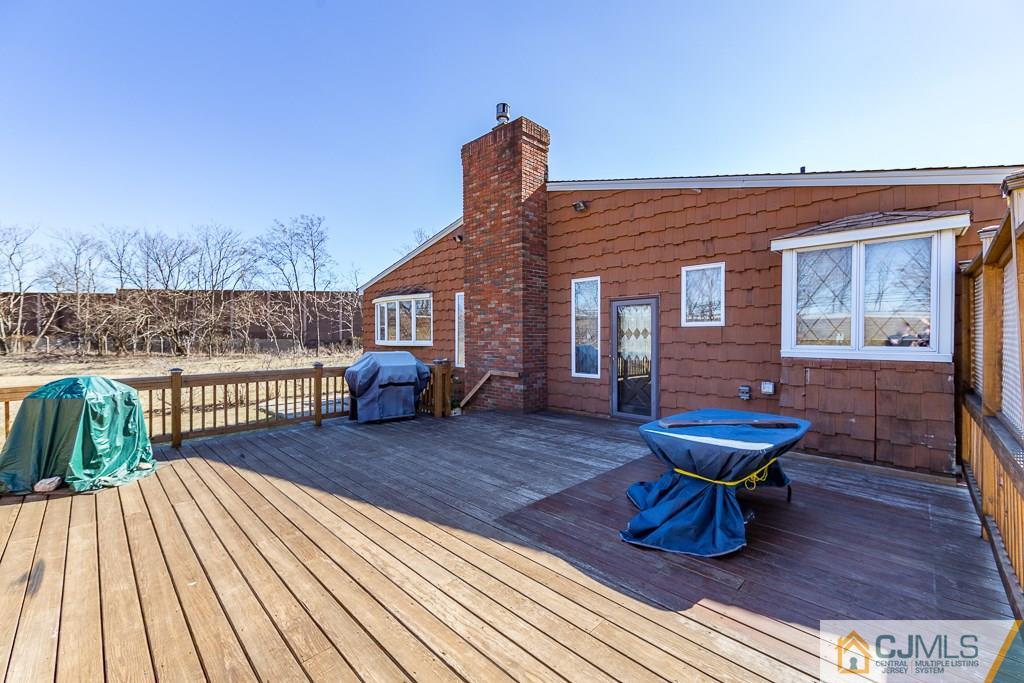 53 Rector Avenue Woodbridge, NJ 07095 - Photo 22 of 25 a view of a roof deck with table and chairs with wooden floor and fence