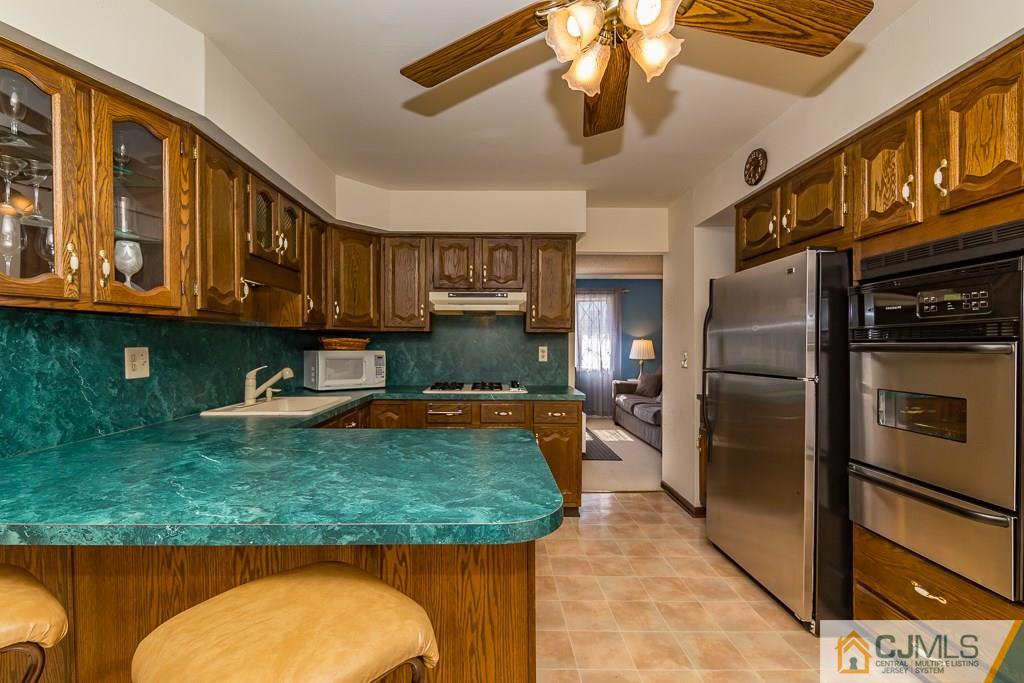 53 Rector Avenue Woodbridge, NJ 07095 - Photo 6 of 25 a kitchen with stainless steel appliances granite countertop a refrigerator a stove and a sink