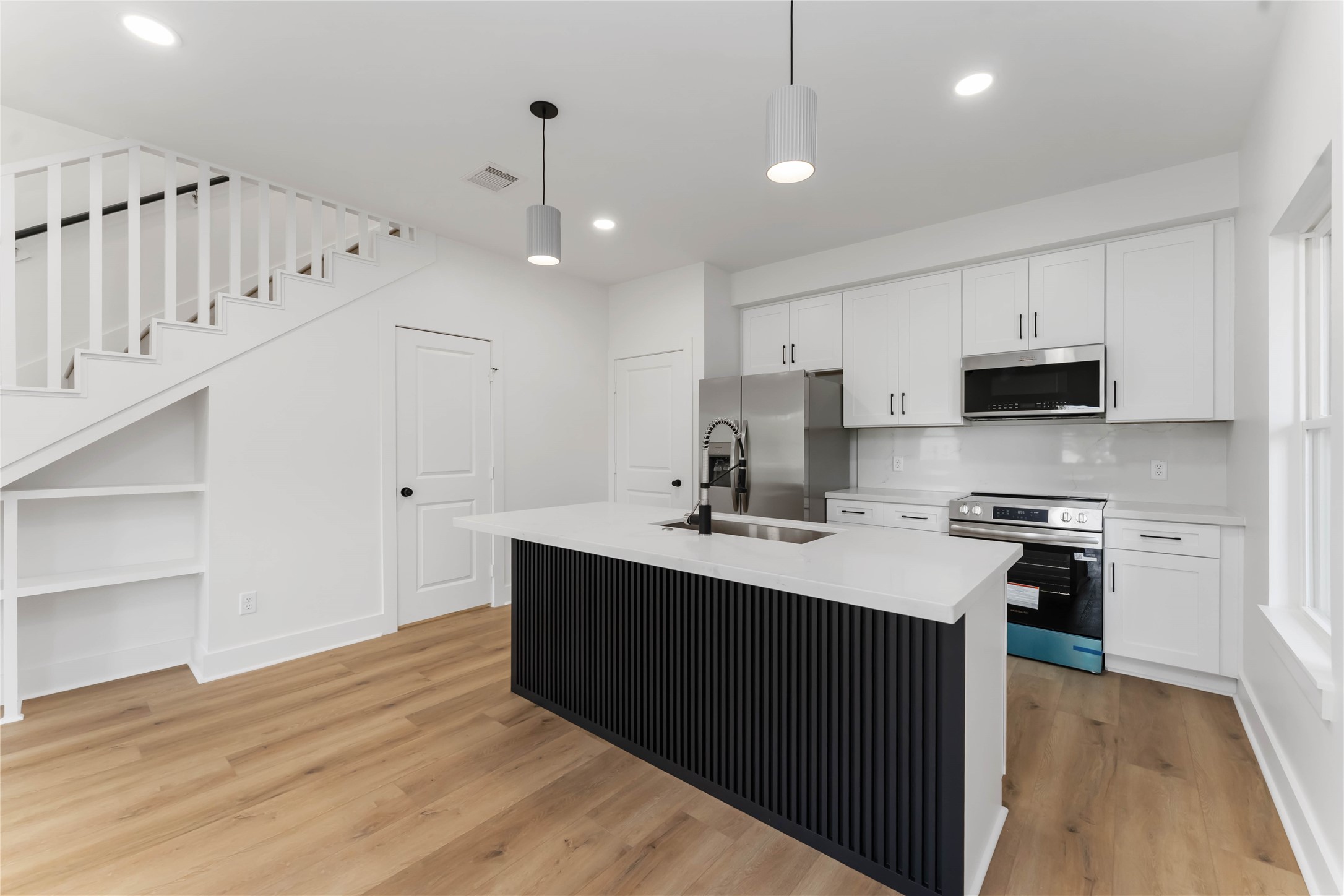 3520 Castor Street, Unit A B Houston, TX 77022 - Photo 27 of 47 a kitchen with stainless steel appliances a sink dishwasher a stove a refrigerator and white cabinets with wooden floor