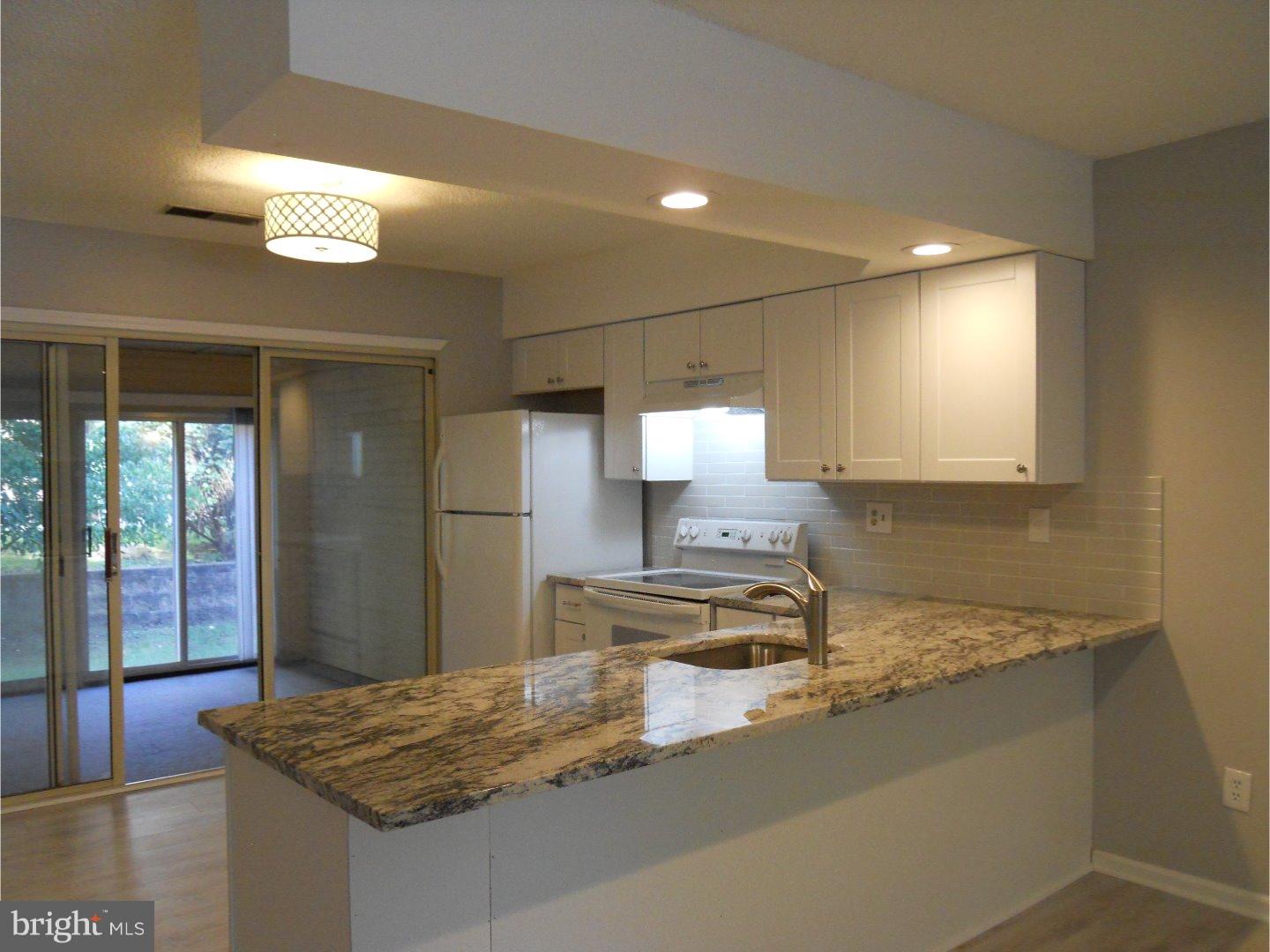 309 Headhouse Court Wayne, PA 19087 - Photo 5 of 16 a kitchen with kitchen island a counter top space a sink stainless steel appliances and cabinets