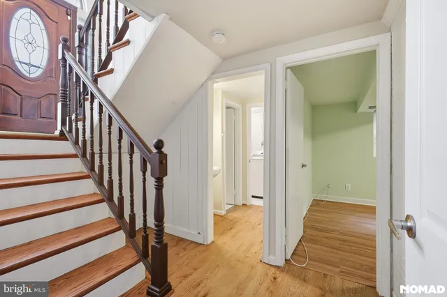 a view of a hallway with wooden floor and entryway