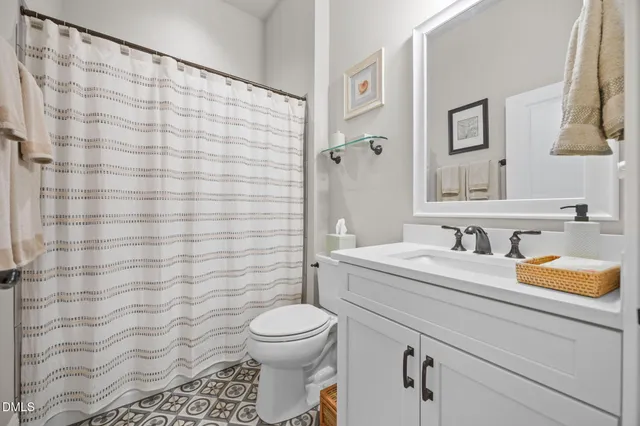 a bathroom with a sink a toilet and shower curtain