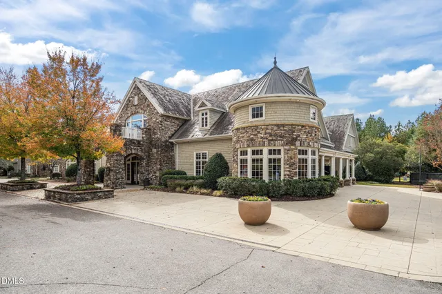 a front view of a building with large trees