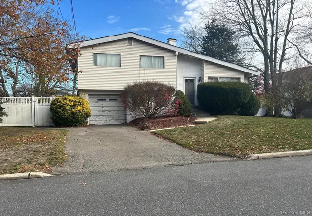 a view of a house with a yard and a large tree