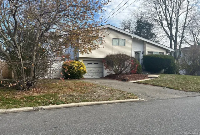 a view of a house with a yard and a large tree