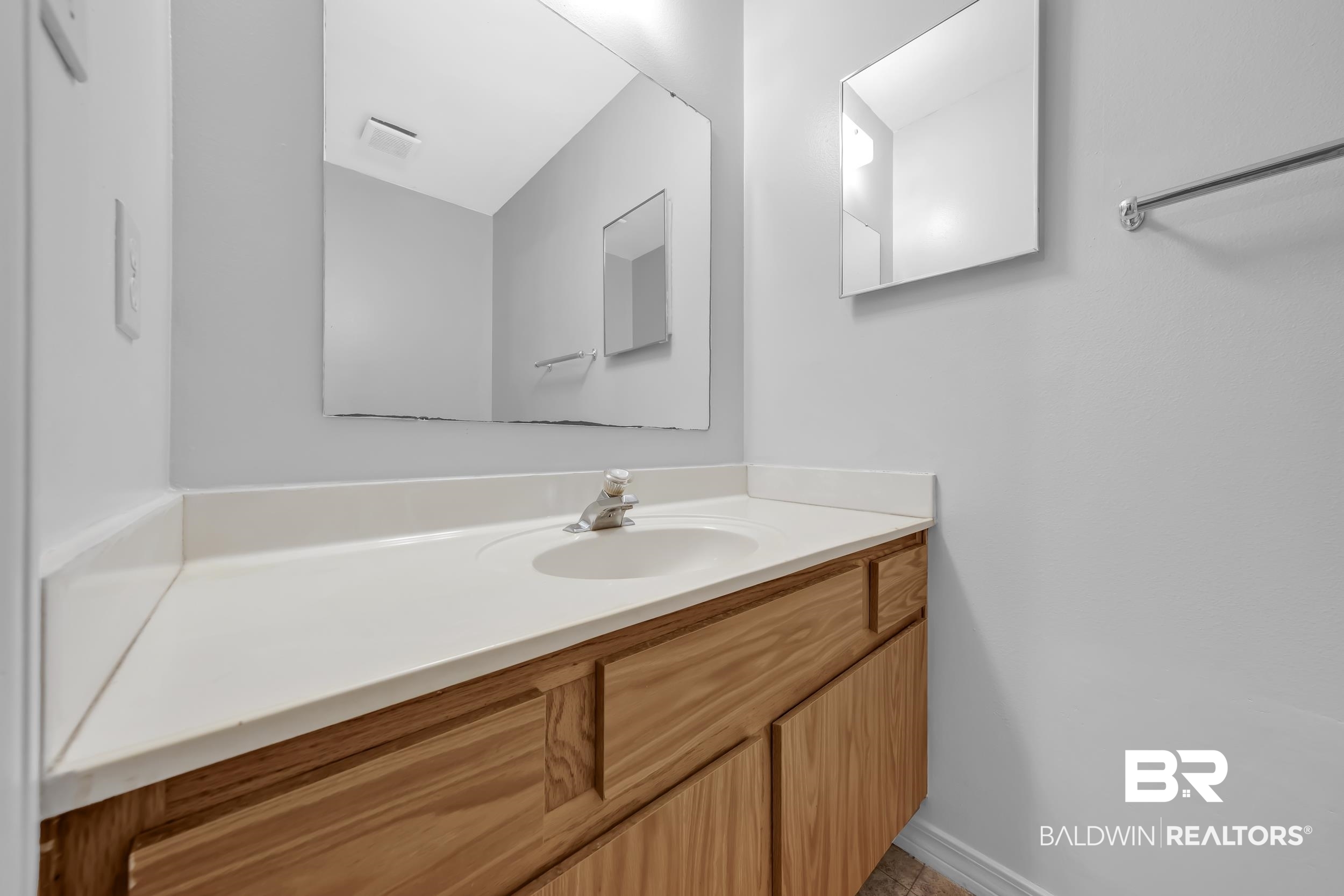 421 Cedar Court Foley, AL 36535 - Photo 31 of 39 Bathroom vanity featuring a light wood-finish cabinet, integrated sink, and a spacious countertop