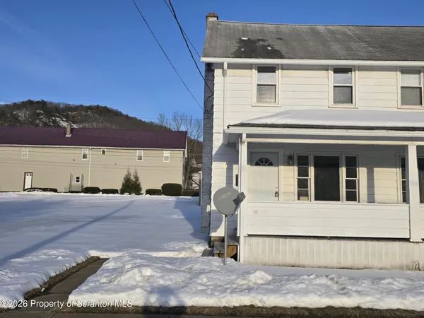 a view of a white house with large windows and a yard