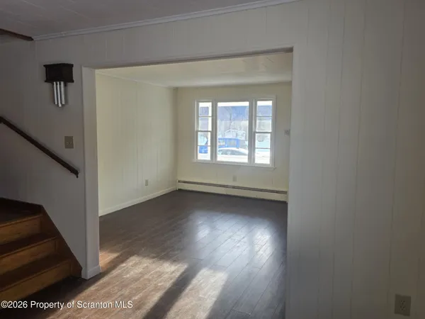 a view of a room that has wooden floor and a window