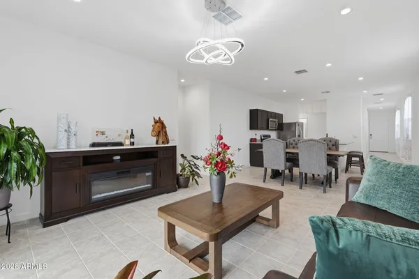 a living room with furniture kitchen and a chandelier