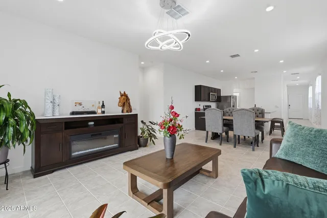 a living room with furniture kitchen and a chandelier