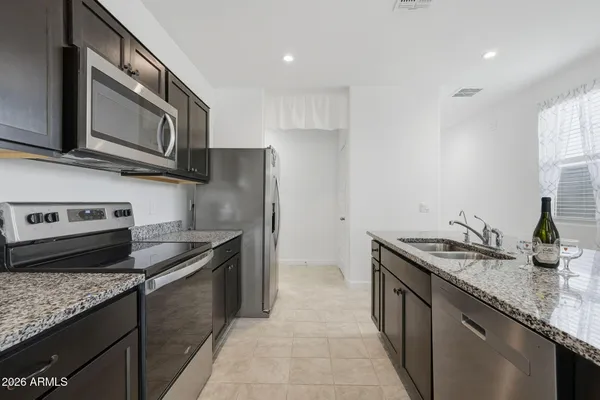a kitchen with stainless steel appliances granite countertop a sink stove and refrigerator