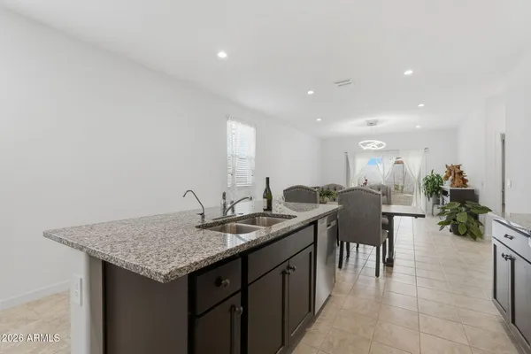 a kitchen with refrigerator and chairs