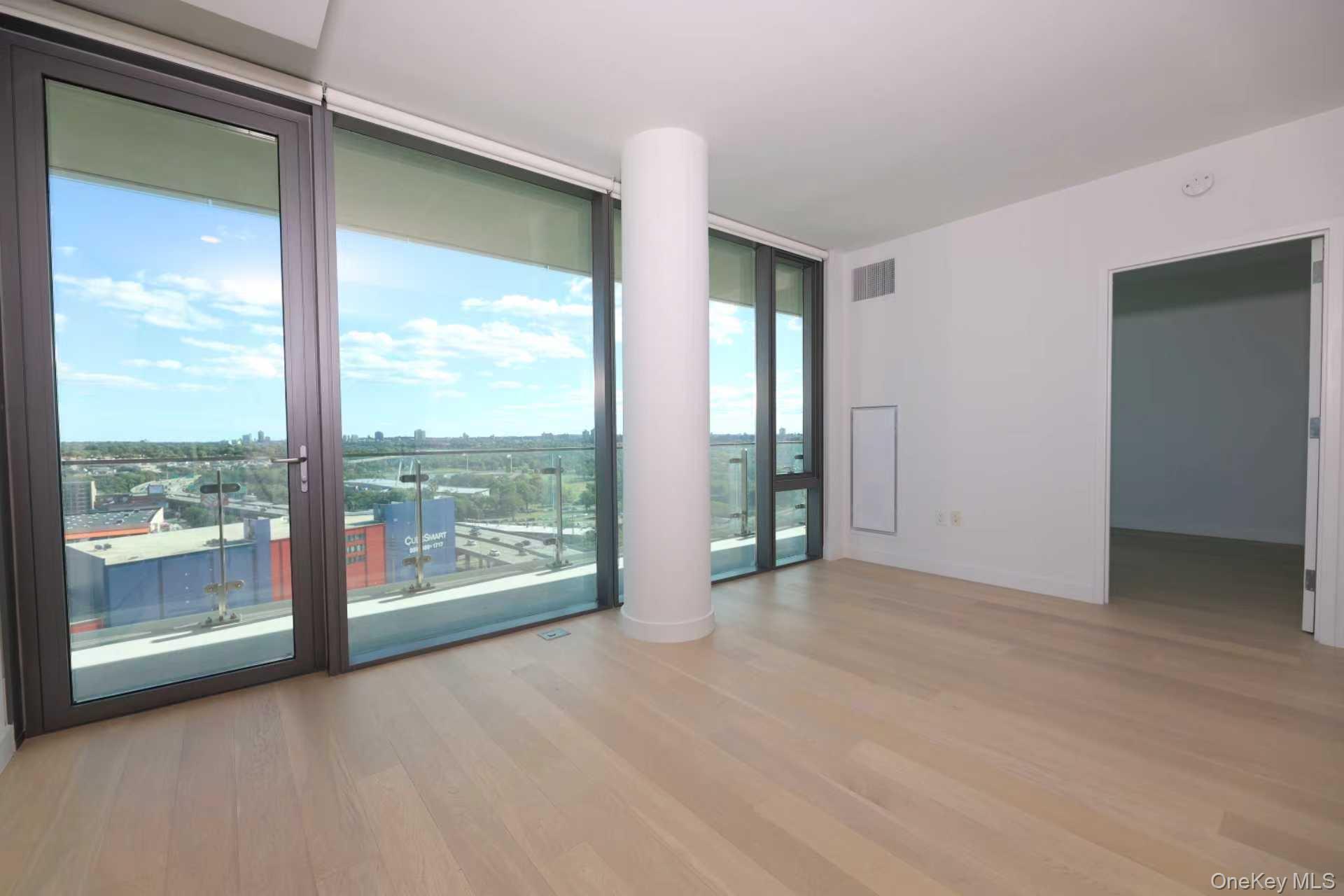 131-01 40 Road, Unit 19P Queens, NY 11354 - Photo 7 of 9 a view of an empty room with glass windows