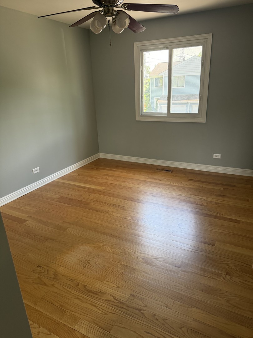 606 Bridgeport Place Wheeling, IL 60090 - Photo 7 of 25 a view of a room with wooden floor and windows