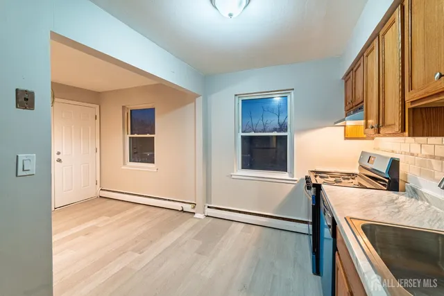 a kitchen with stainless steel appliances granite countertop a stove a sink and a refrigerator