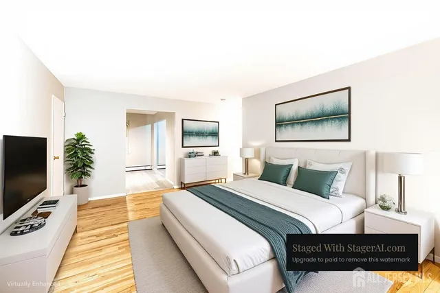 a bedroom with a bed a tv and wooden floor