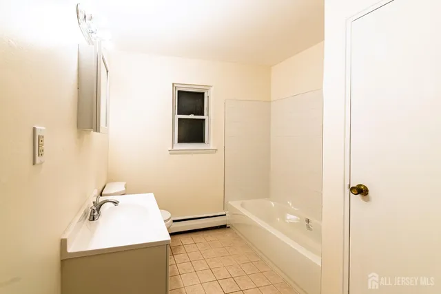 a bathroom with a tub sink and mirror