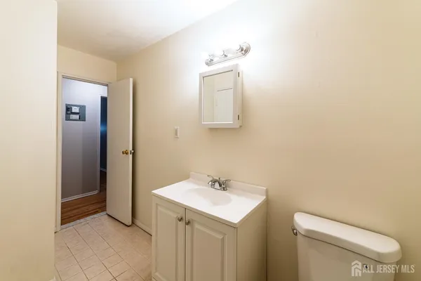 a bathroom with a toilet a sink and mirror