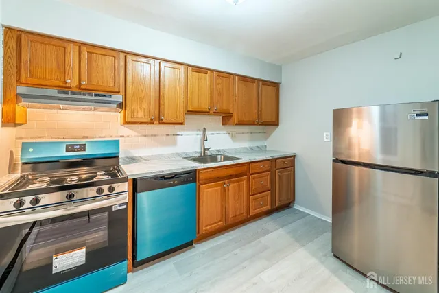 a kitchen with a refrigerator stove and sink