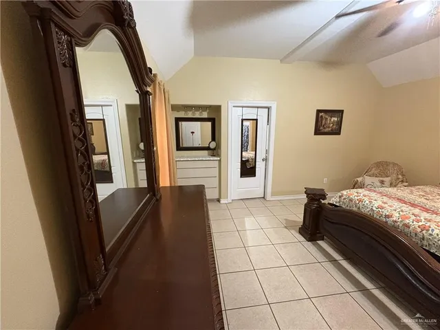 a bedroom with a bed and a refrigerator